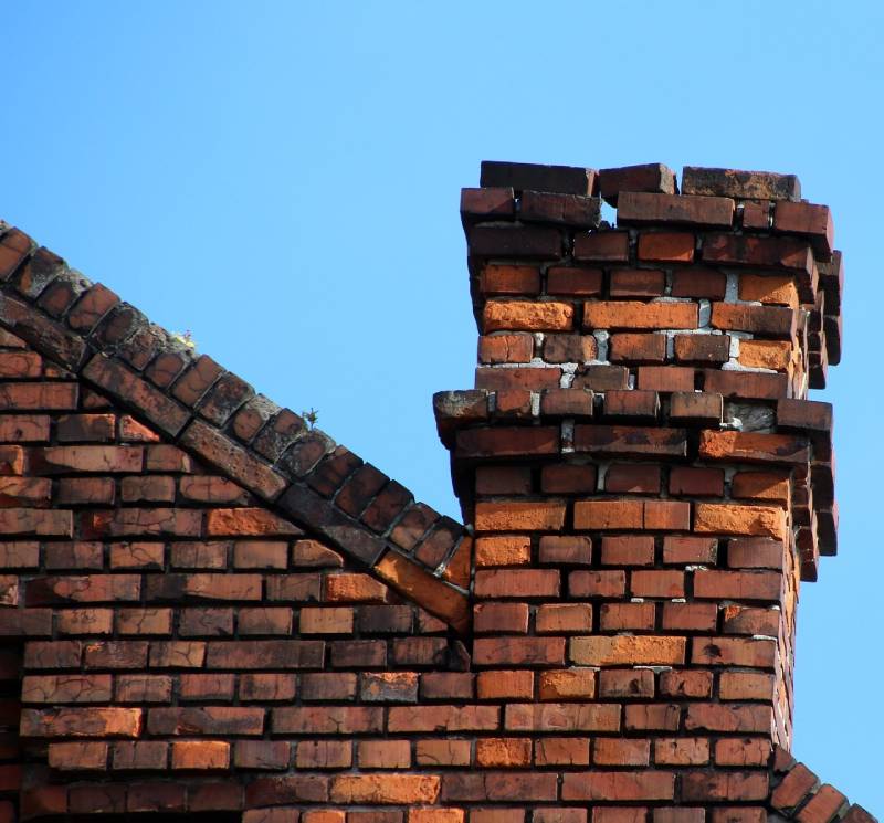 Damaged chimney on an Joliet home showing cracks and missing mortar